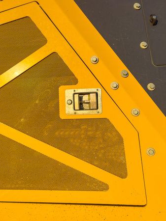 A close-up shot shows a metal structure with a yellow surface. The design includes a rectangular...