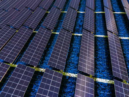 Rows of solar panels are arranged on a rooftop, capturing sunlight for energy production. The...