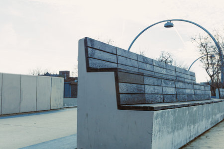 A wooden bench sits in a public area during winter. The lack of people around highlights the bench...