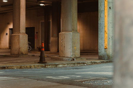 Concrete pillars support a structure in an urban setting where a bicycle is parked on the ground...