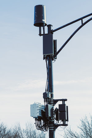 A wireless communication tower is visible with various devices attached. It is located in an open...