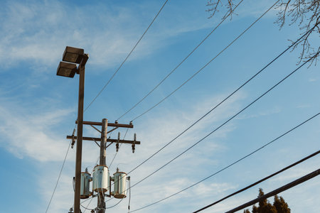 Electric poles are visible with power lines stretching across a clear sky. The scene shows a typical...