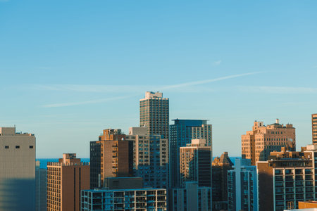 Various buildings in a city with a view of the water in the background. The sky is clear, and the...