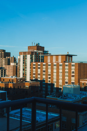 Several buildings fill the city skyline as the sun sets. The scene shows rooftops, windows, and a...
