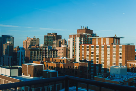City skyline shows tall buildings and a clear blue sky during the early morning light in an urban...