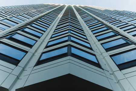 View of a tall building from the ground looking up at the windows and sky showing the angle of the...