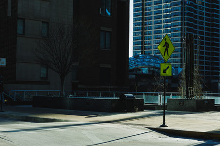 Walk sign placed on a city street near a tall building during daylight hours in an urban area