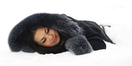 Portrait of beutiful asian young woman lying in the snow and dreaming or sleeoing. Girl isolated on white background.の写真素材