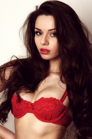 studio glamour picture of female model posing in red lingerieの写真素材