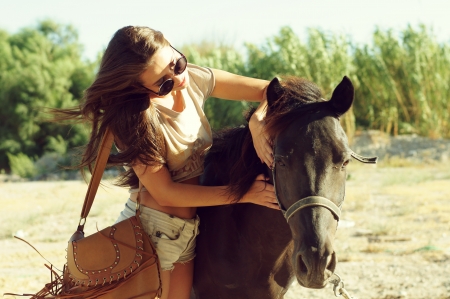 beautiful young woman with brown horse outdoorsの写真素材