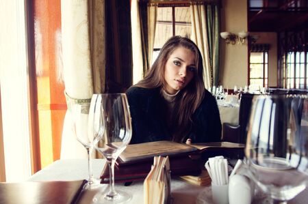 beautiful girl reading menu in restourant