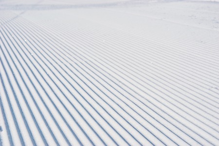 Prepared snowcat track at alpine skiing resort on a sunny dayの写真素材