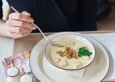 woman eating cheese cream soupの写真素材