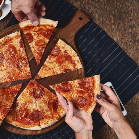 Hands holding pizza slices.の写真素材
