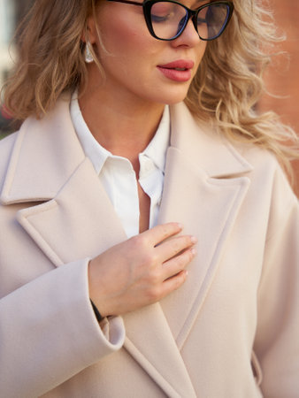 Stylish woman in casual streetstyle coat enjoys sunny day in the cityの写真素材