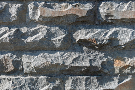 A gray stone wall made of rough stones.