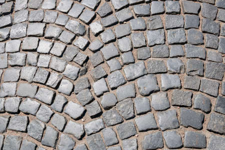 Background or texture of pavement paved with arched gray cobblestones, stonesの写真素材