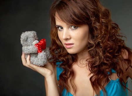 Sexy young girl on black background with teddy bearの写真素材