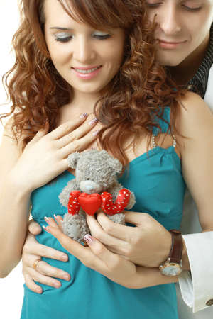 Young attractive happy smiling couple isolated on white with teddy bearの写真素材