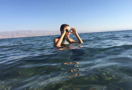 Professional triathlete practicing in open water. Swimming in sea. Triathlon training in wetsuit.の写真素材