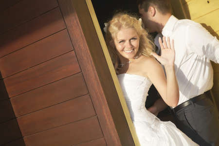 Lovely bride saying good bye near door after wedding. Warm summer day, wedding at tropical caribbean island or Hawaii.の写真素材