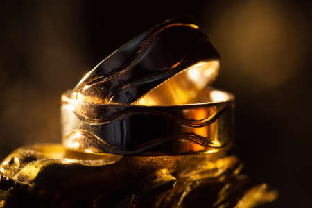 Wedding rings in the rays of yellow light.の写真素材