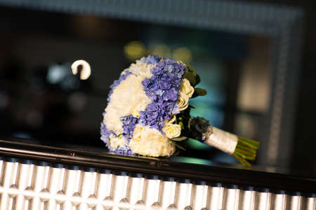 Wedding bouquet of white and purple flowers on the tableの写真素材