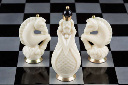 Glass chess pieces on a metal chessboardの写真素材
