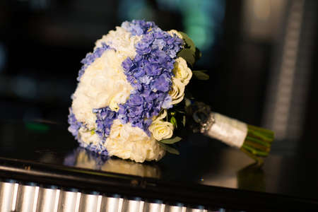 Wedding bouquet of white and purple flowers on the tableの写真素材