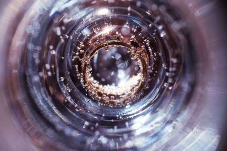 Wedding rings in a glass of water and air bubblesの写真素材