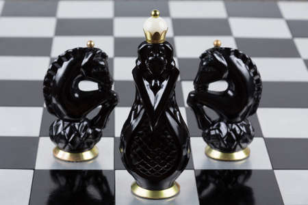 Glass chess pieces on a metal chessboardの写真素材