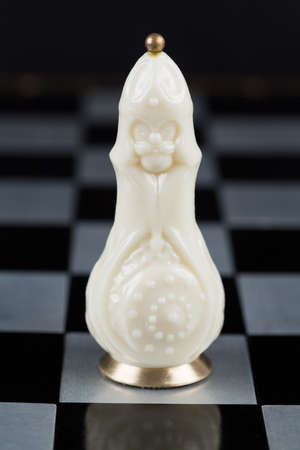 Glass chess pieces on a metal chessboardの写真素材