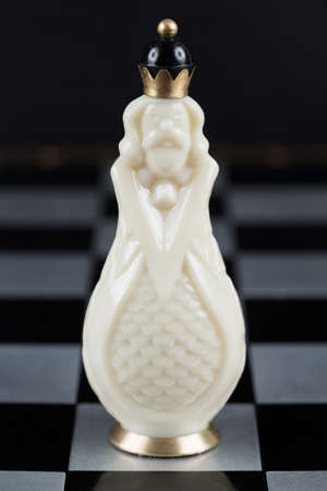 Glass chess pieces on a metal chessboardの写真素材