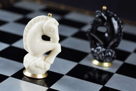 Glass chess pieces on a metal chessboardの写真素材