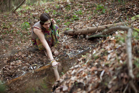 The girl in the woods near a streamの写真素材