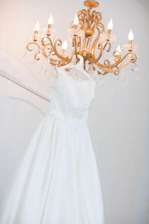 Wedding dress on the chandelier. Morning of the brideの写真素材