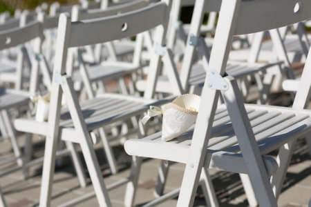 Rose petals for wedding in the bags on white chairsの写真素材