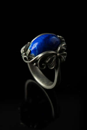 Silver ring with lapis lazuli on a black background.の写真素材