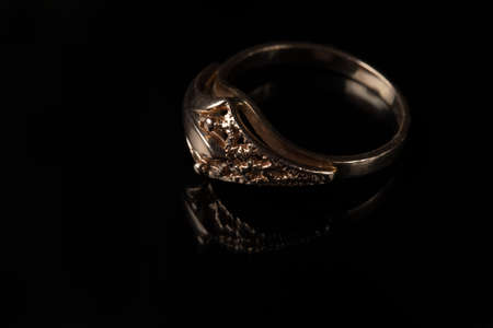 Gold ring with a pattern on a black background.の写真素材