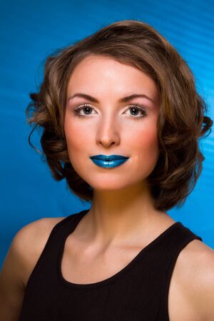 Fashion portrait of woman with fashion makeup - blue lips, blue backgroundの写真素材