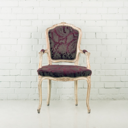 Wooden vintage chair against a brick wallの写真素材