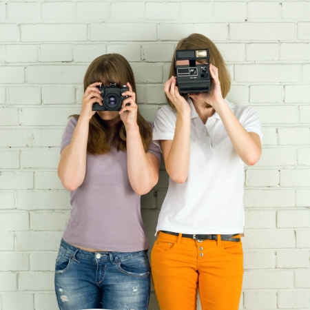  Young girls taking picture with a old vintage camerasの写真素材