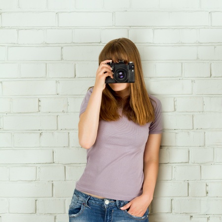 Young girl taking picture with a old vintage camera