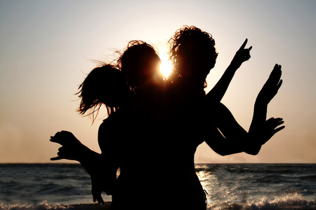Group of young women having fun on the beach at sunset  Girls silhouettes outdoorの写真素材