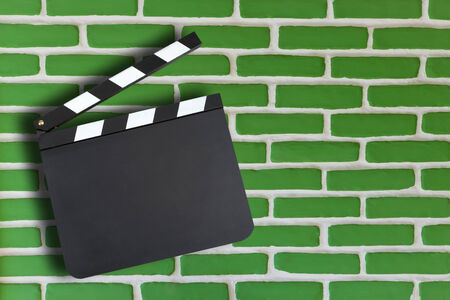 Blank movie production clapper board over brick wall background with copy space の写真素材