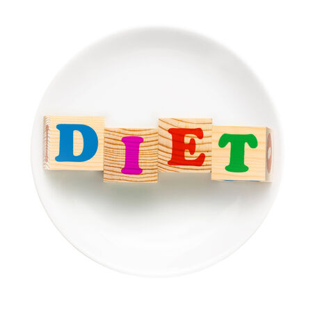 White plate with word diet composed of wooden cubes. Isolated on a white background. Dieting conceptの写真素材