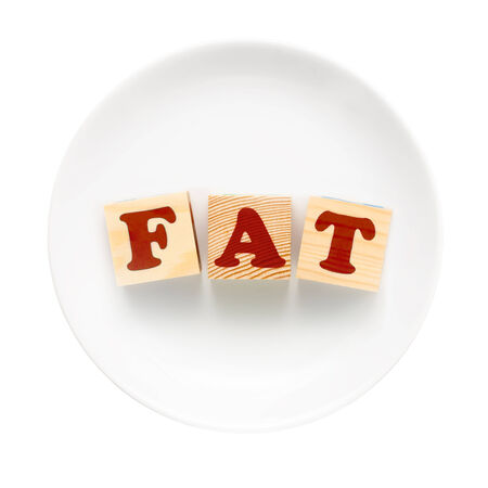 White plate with word FAT composed of wooden blocks. Isolated on a white background.の写真素材