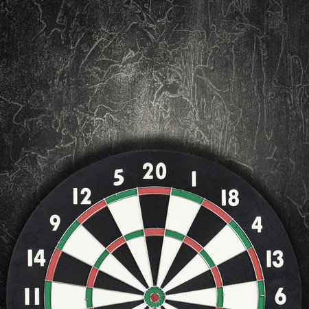 Darts board against vintage dark background. Cracked textureの写真素材