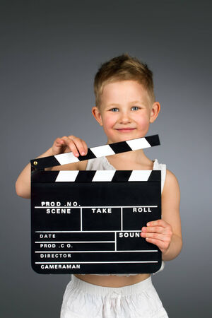Smiling kid holding movie clapper board. Cinema or casting conceptの写真素材