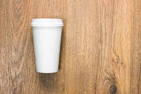 Top view of a blank coffee cup on a wooden background.の写真素材